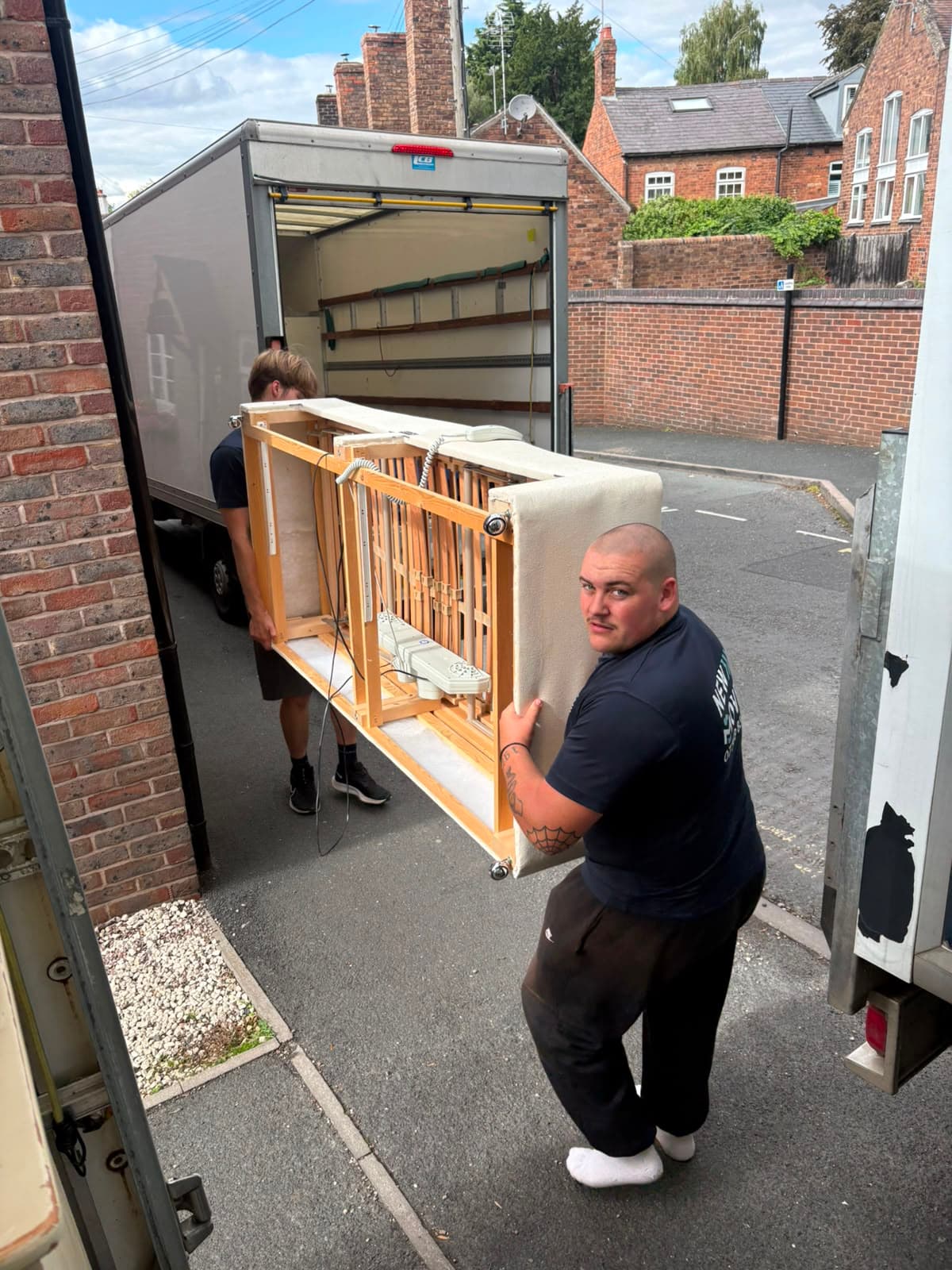 New Moves Removals team members carefully carrying a dismantled piano frame