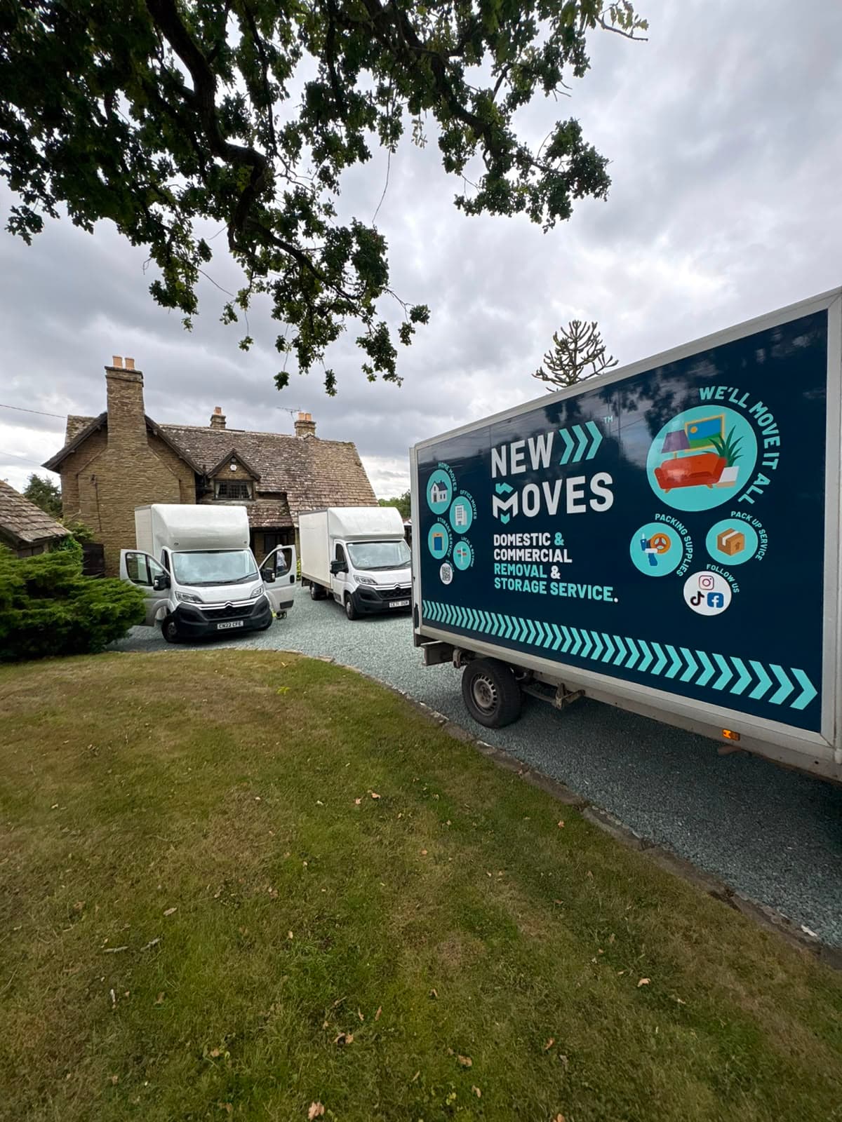 New Moves Removals team members and two vans outside a stone farmhouse