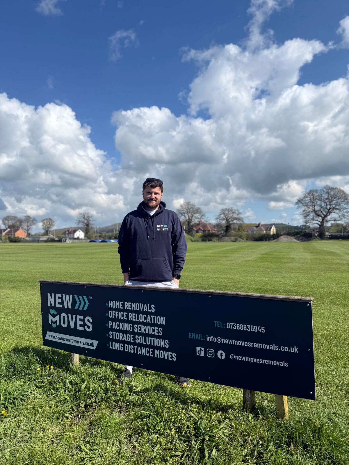 Two New Moves Removals team members beside their van outside a modern home