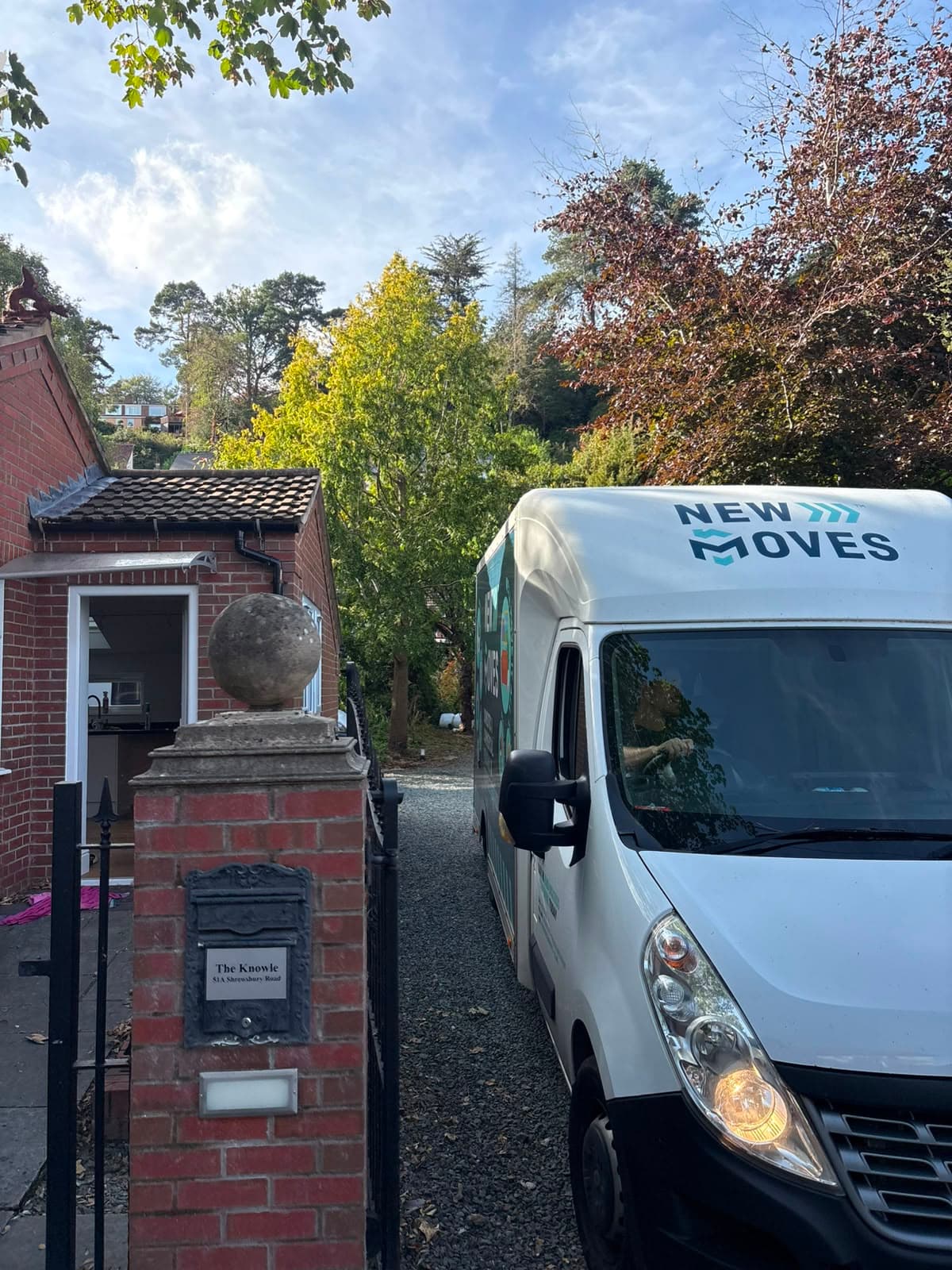 A New Moves Removals van navigating a narrow gated driveway