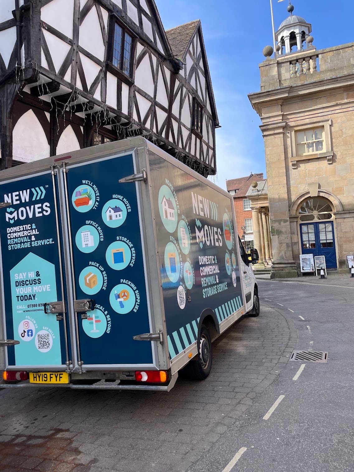 A New Moves Removals van parked beside a timber-framed building in Ludlow town centre