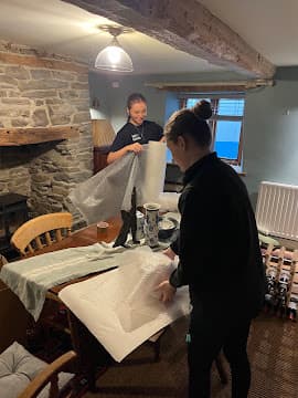 Two New Moves Removals team members wrapping furniture in protective film