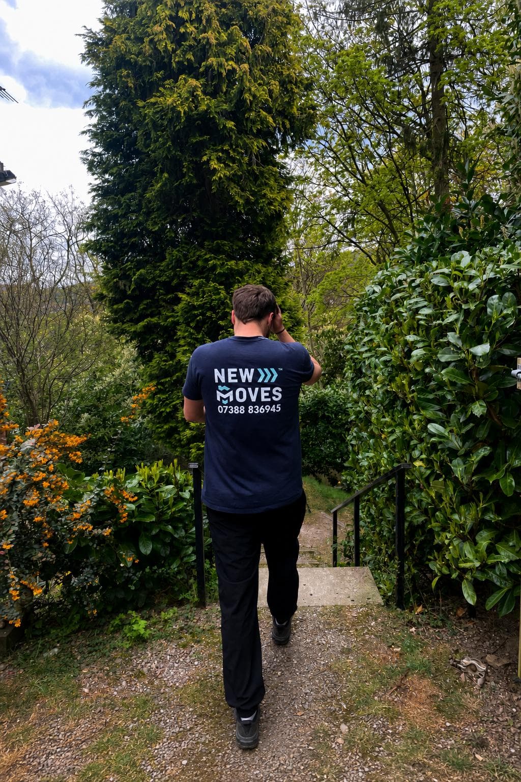 A New Moves Removals team member beside a branded sign in an open field
